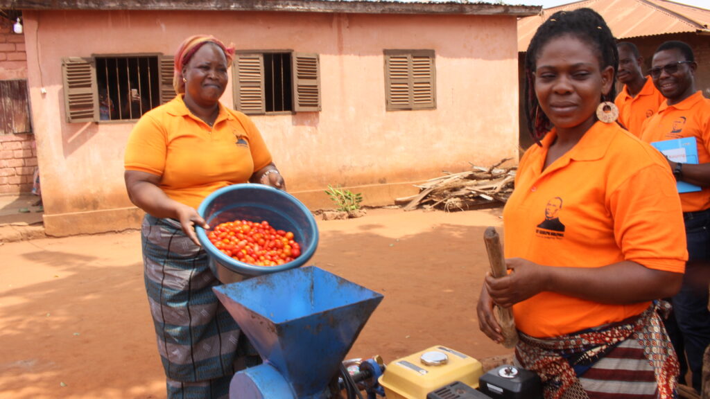 Photo, Les Femmes de Légbanou démontre l'utilisation de la machine à moudre la tomation